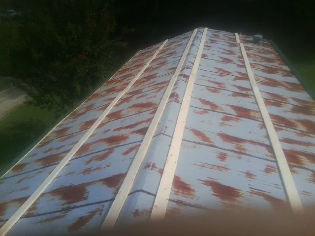 Rusted metal roof panels with new wood purlins before replacement — Storm Damage Roof Repair in Romeo by Roofing Brothers