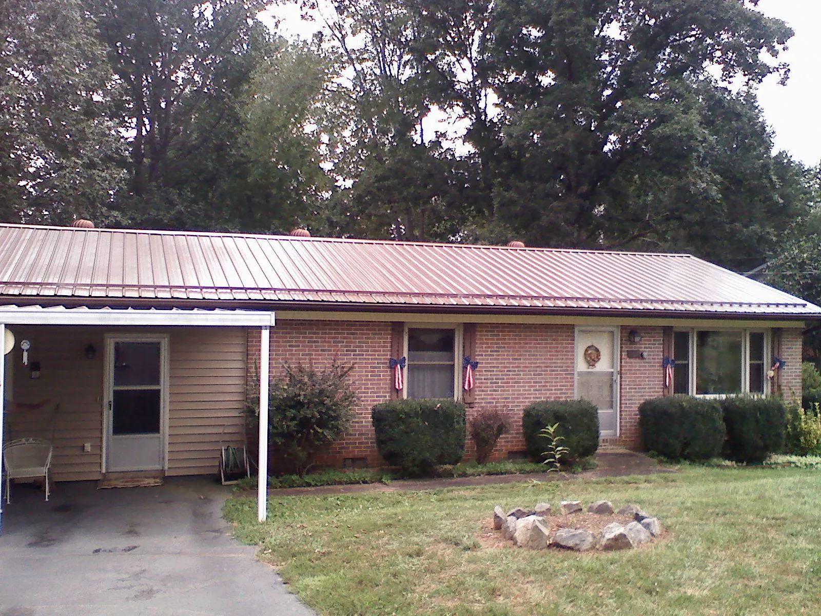 Bronze metal roof and carport on a brick ranch home — Roof Repair work by our crew in Romeo