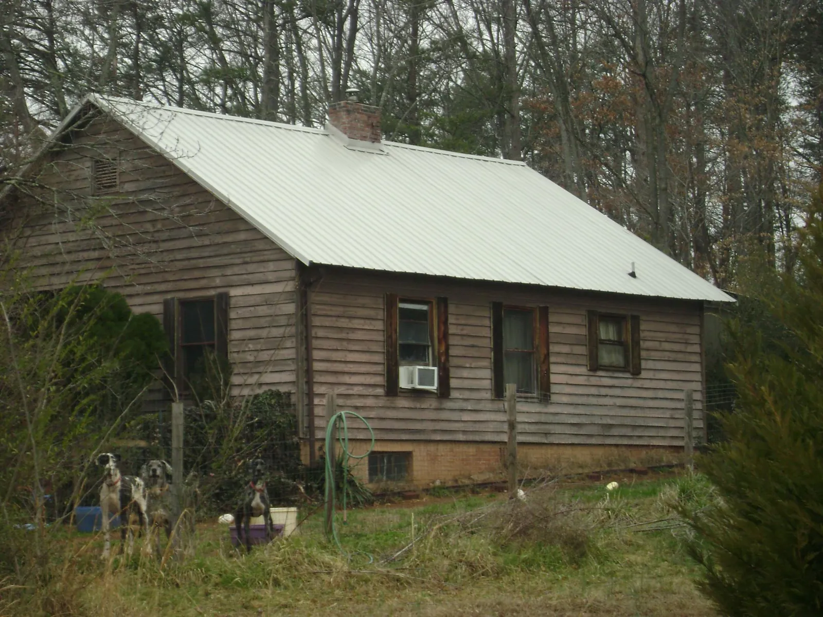 White metal roof on an old wood sided farmhouse, from a Metal Roof Installation job in Romeo
